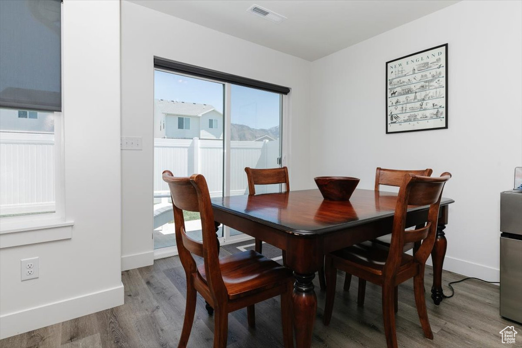Dining space with baseboards, wood finished floors, and visible vents