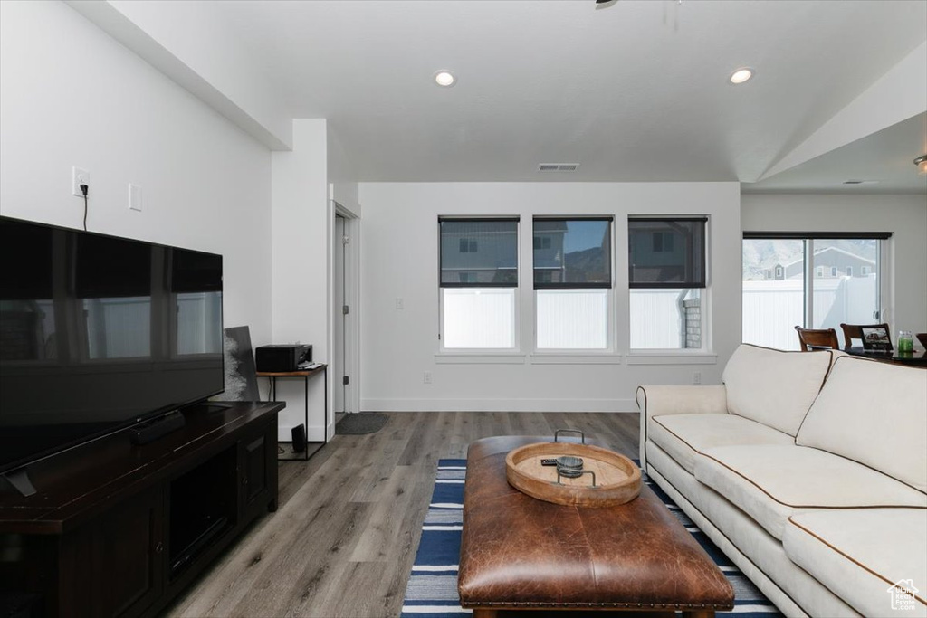 Living area with recessed lighting, baseboards, visible vents, and light wood finished floors