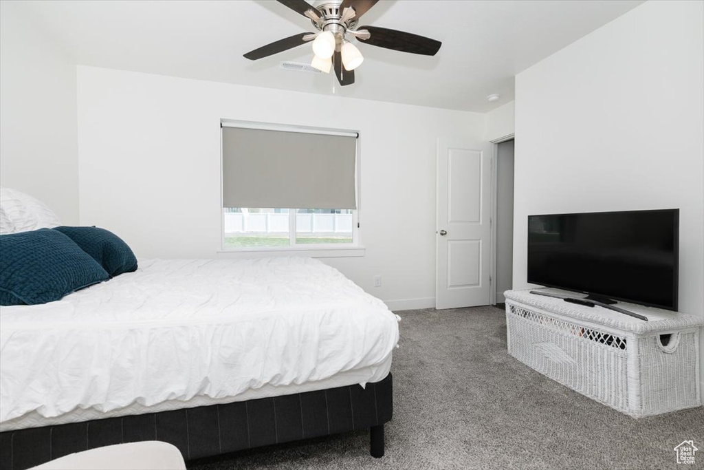 Carpeted bedroom featuring baseboards and a ceiling fan