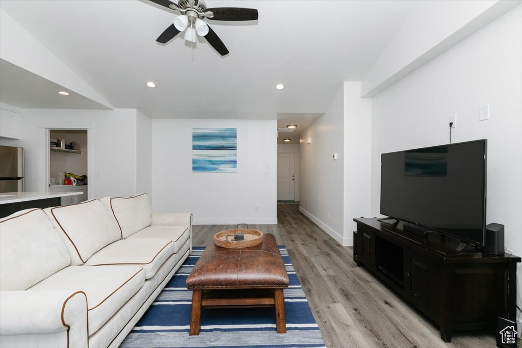 Living area with a ceiling fan, baseboards, recessed lighting, and light wood finished floors