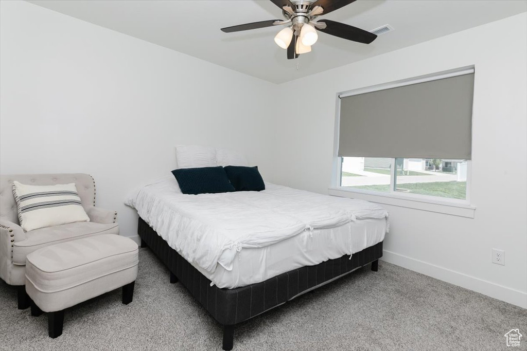 Carpeted bedroom featuring baseboards, visible vents, and ceiling fan
