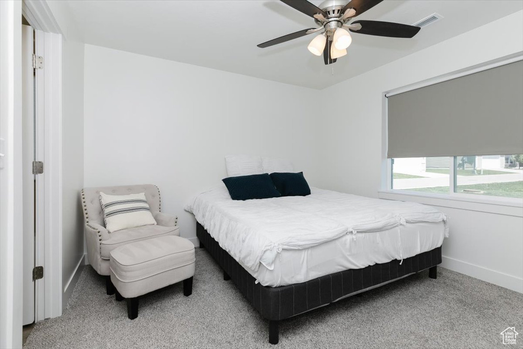 Bedroom featuring carpet floors, baseboards, visible vents, and ceiling fan