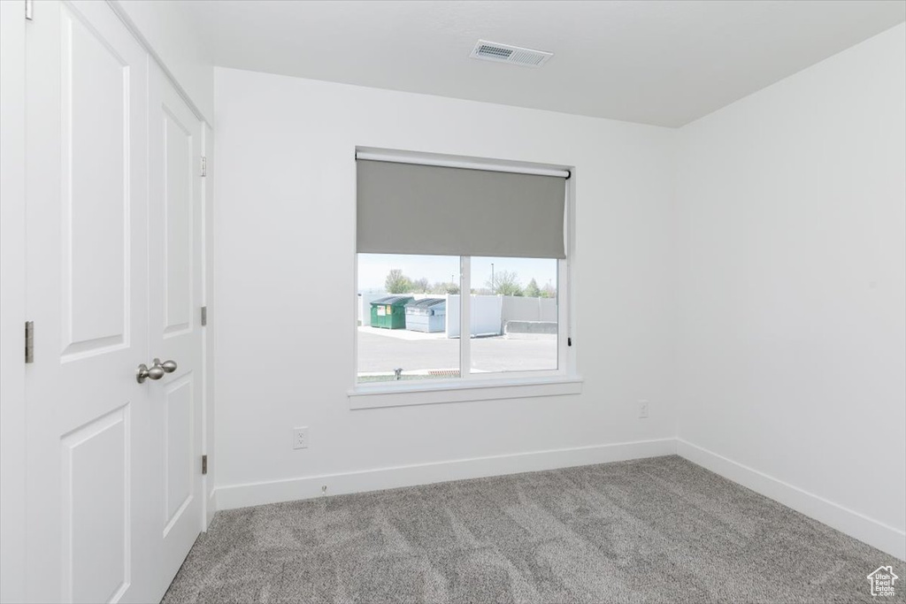 Spare room with baseboards, visible vents, and carpet