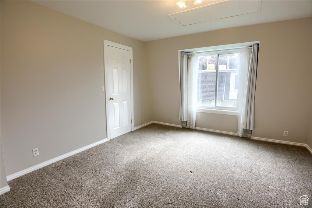Carpeted spare room with baseboards