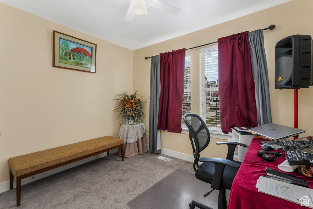 Carpeted office with a wealth of natural light, baseboards, a ceiling fan, and visible vents
