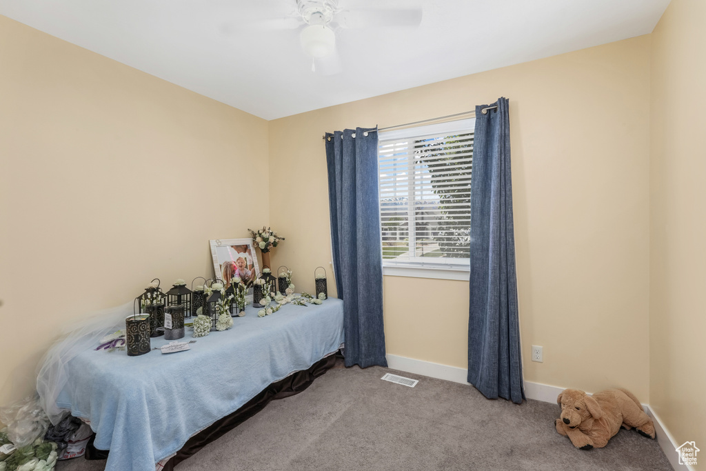Bedroom featuring carpet flooring, visible vents, baseboards, and ceiling fan