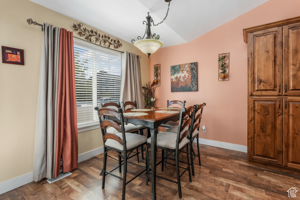 Dining space with baseboards, dark wood-style flooring, and visible vents