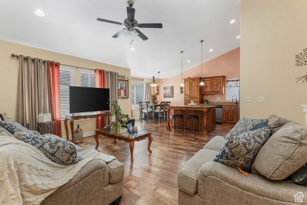 Living room with vaulted ceiling, ceiling fan, dark wood-style flooring, and recessed lighting