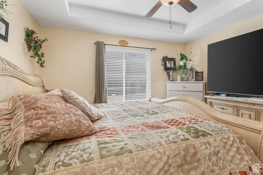 Bedroom featuring a ceiling fan and a raised ceiling