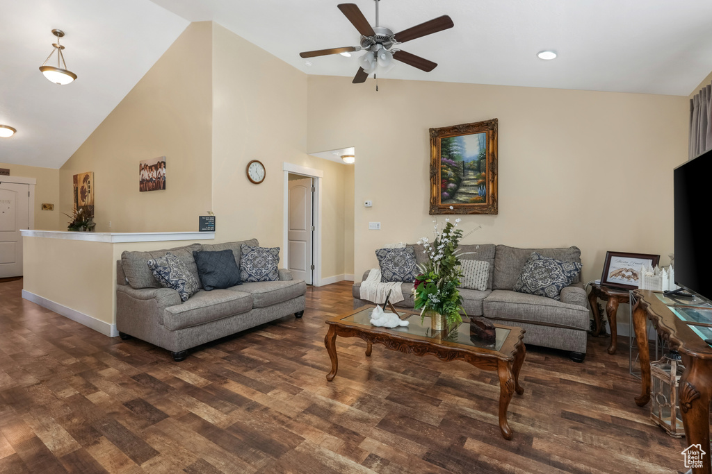 Living area with a ceiling fan, baseboards, high vaulted ceiling, and wood finished floors