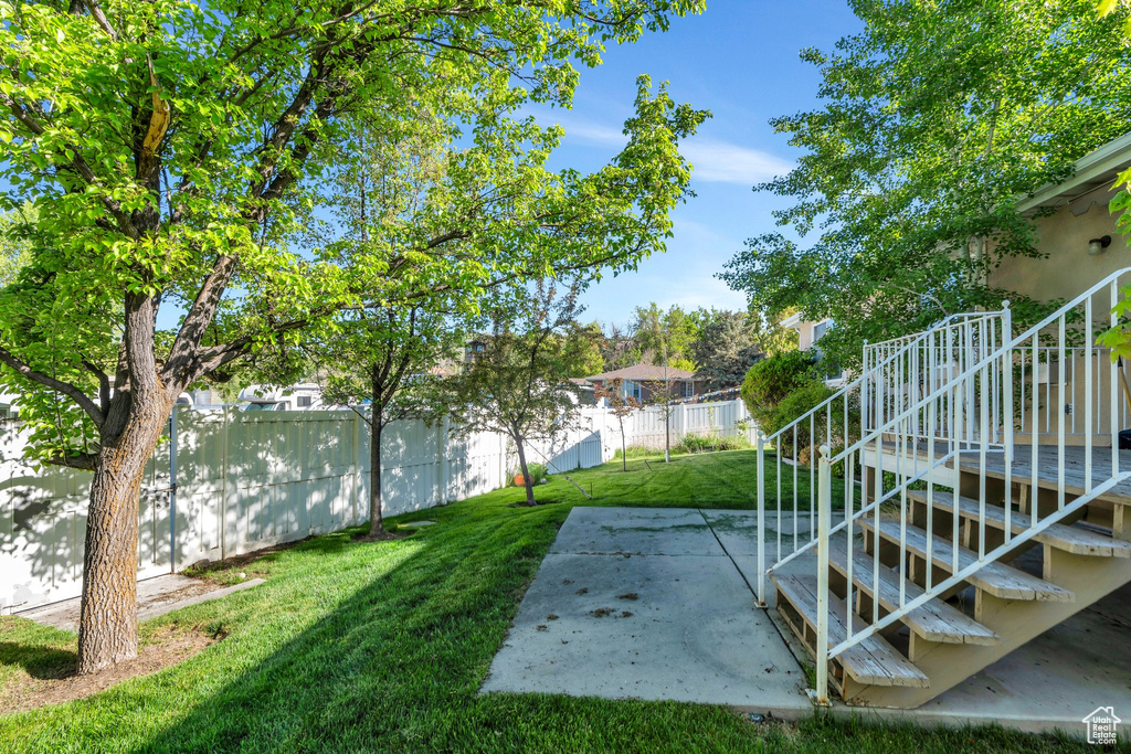 View of yard featuring a patio, a fenced backyard, and stairs