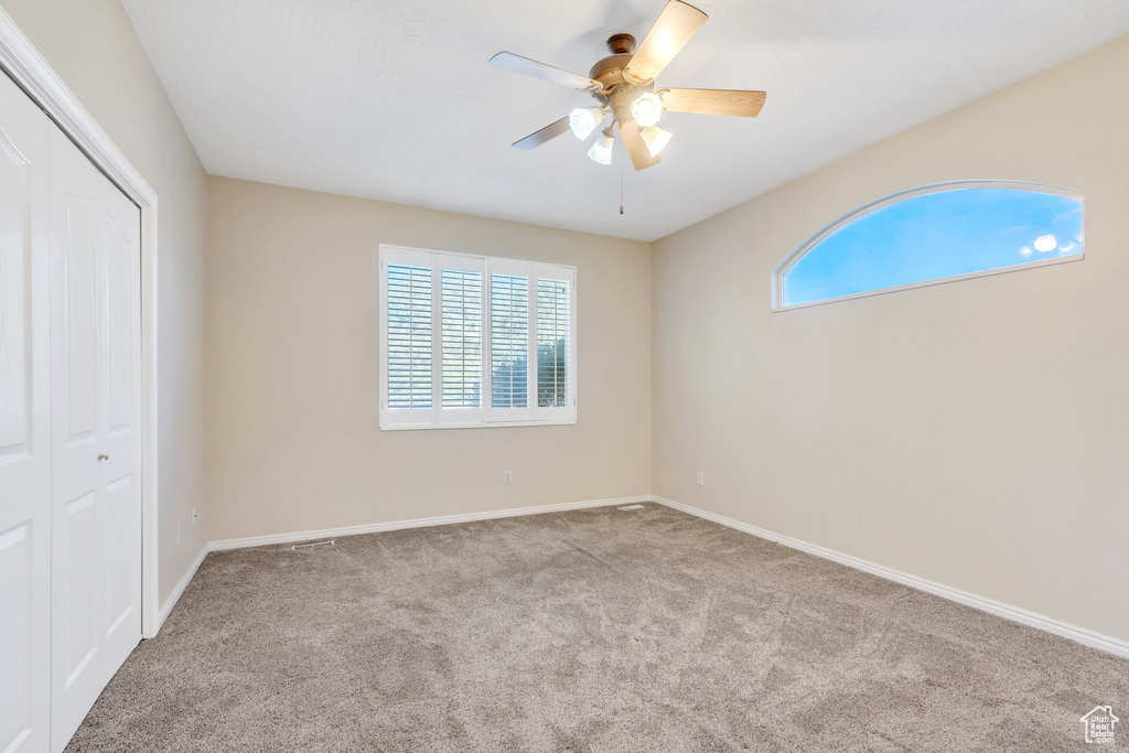 Unfurnished bedroom featuring baseboards, carpet flooring, a closet, and a ceiling fan