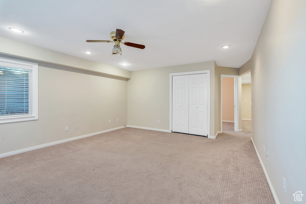 Unfurnished bedroom with a closet, recessed lighting, baseboards, ceiling fan, and light colored carpet