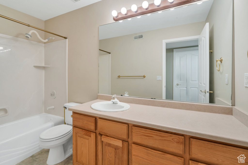 Full bathroom featuring toilet, vanity, visible vents, tile patterned floors, and bathing tub / shower combination