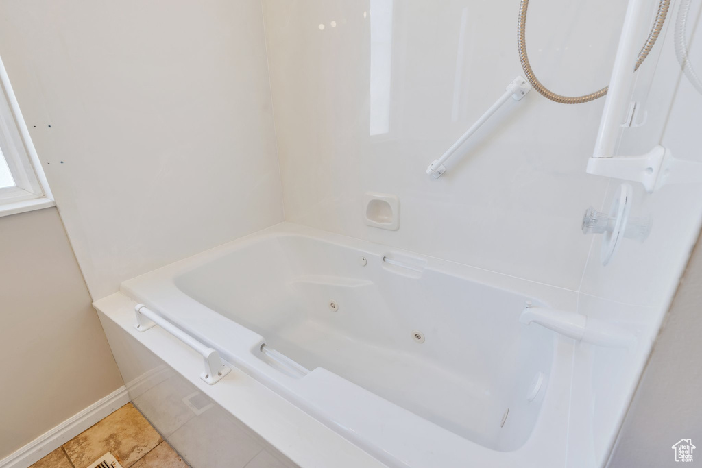 Full bathroom with tile patterned flooring, a jetted tub, and baseboards