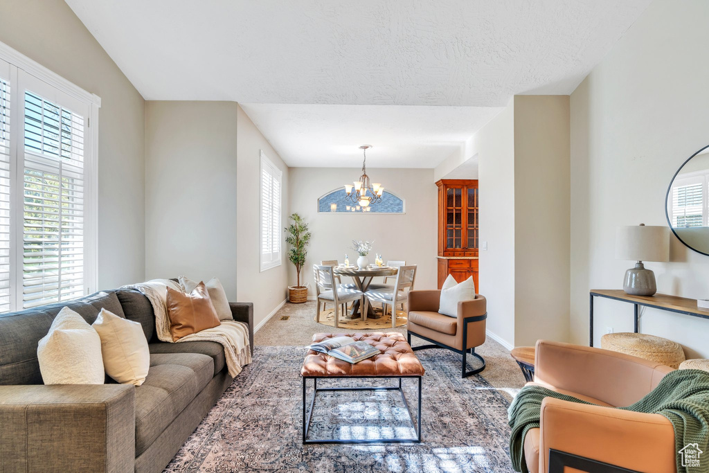 Living area with baseboards, a healthy amount of sunlight, and a chandelier