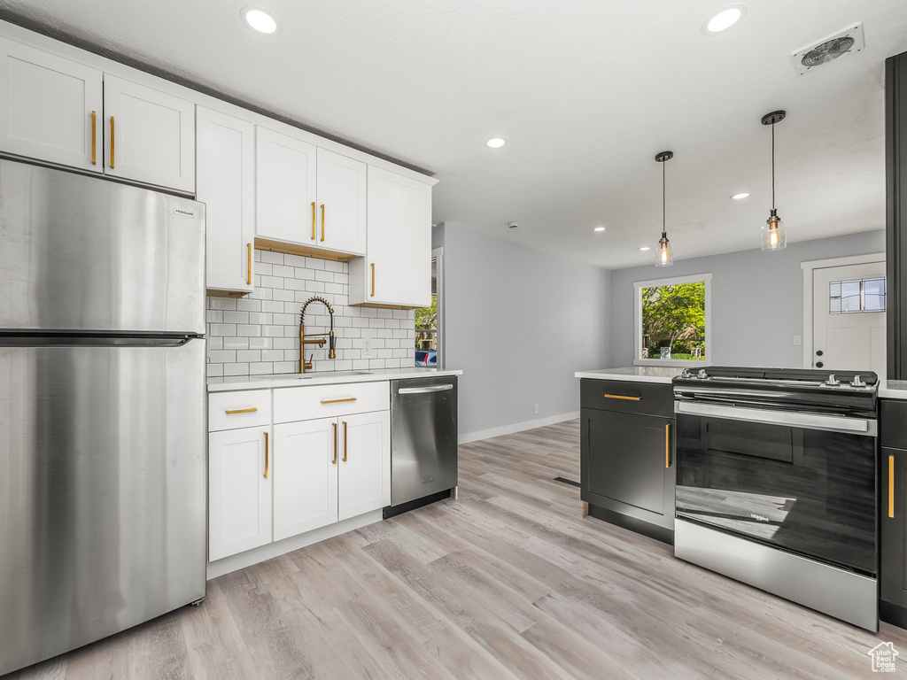 Kitchen featuring a sink, white cabinets, visible vents, light countertops, and appliances with stainless steel finishes