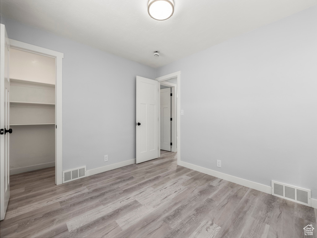 Unfurnished bedroom featuring baseboards, visible vents, and wood finished floors