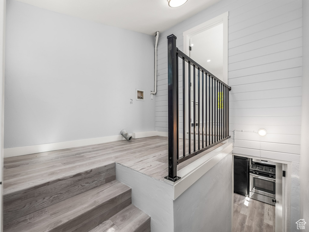 Stairway with wood finished floors and baseboards