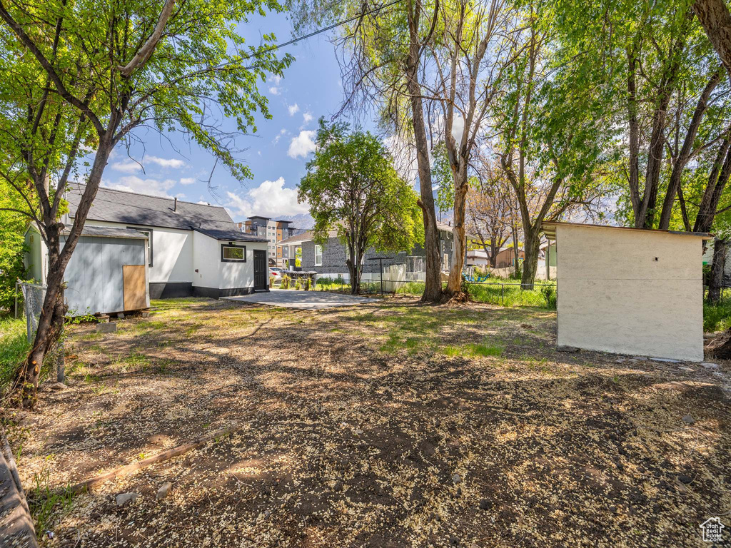 View of yard featuring an outdoor structure, a storage shed, and fence