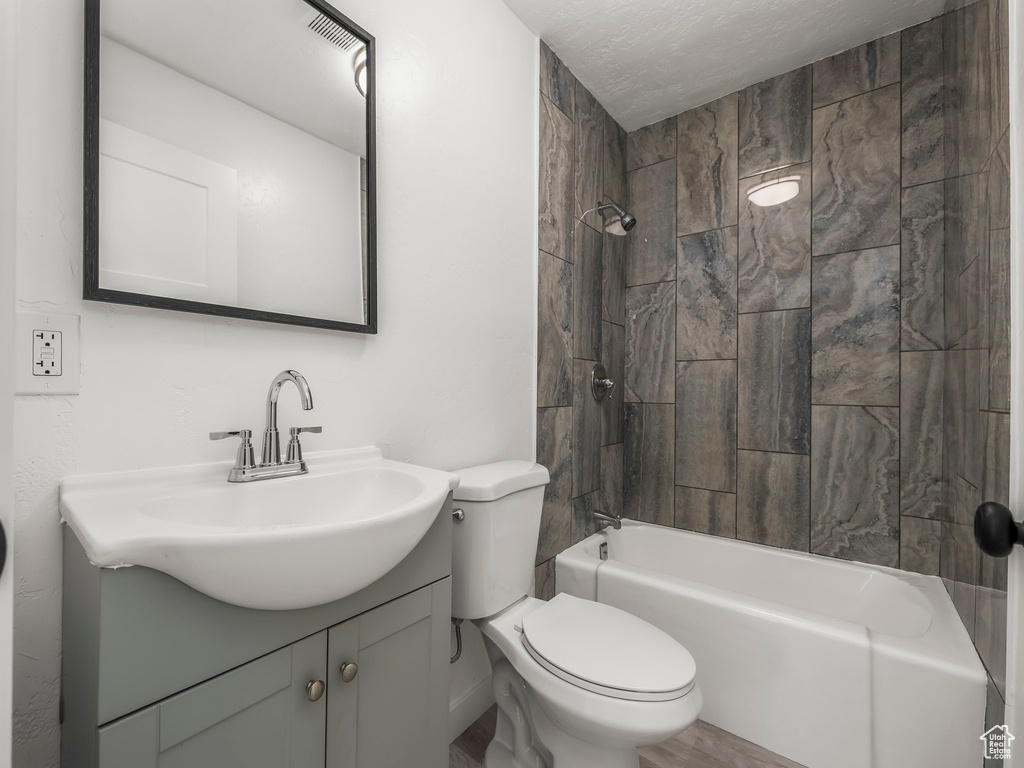 Full bathroom featuring toilet,  shower combination, vanity, and wood finished floors