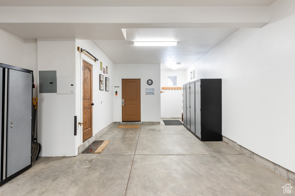Hall with electric panel, concrete floors, and a barn door