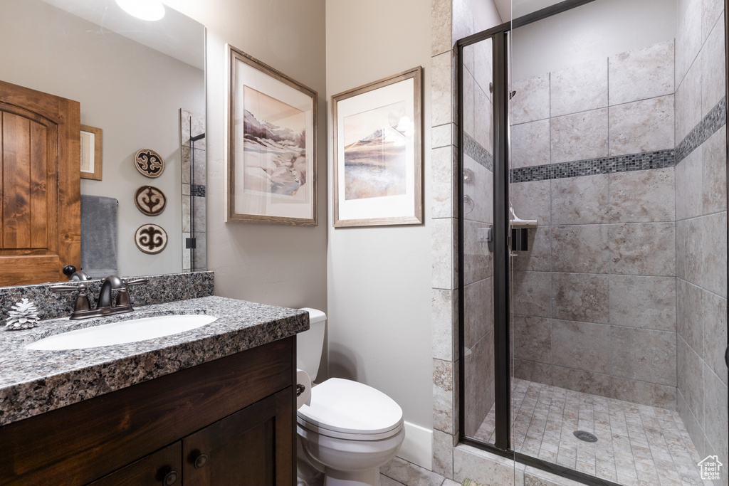Bathroom featuring vanity, a stall shower, and toilet