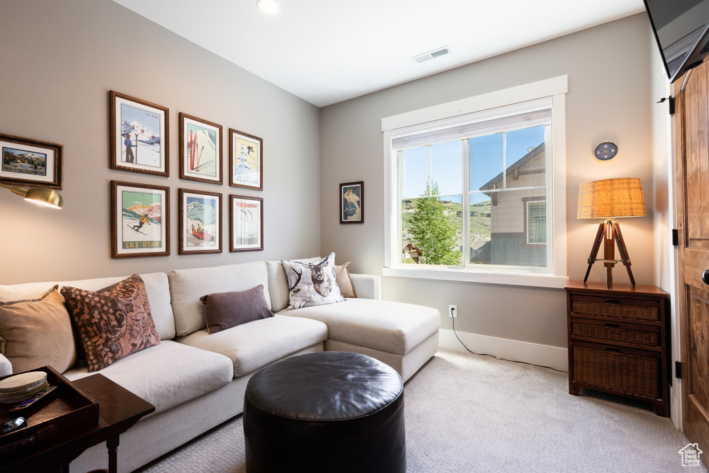 Living area featuring carpet floors, baseboards, and visible vents