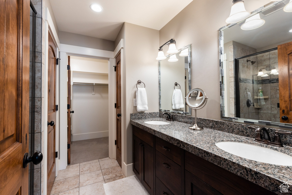 Bathroom with visible vents, a sink, a spacious closet, and a shower stall