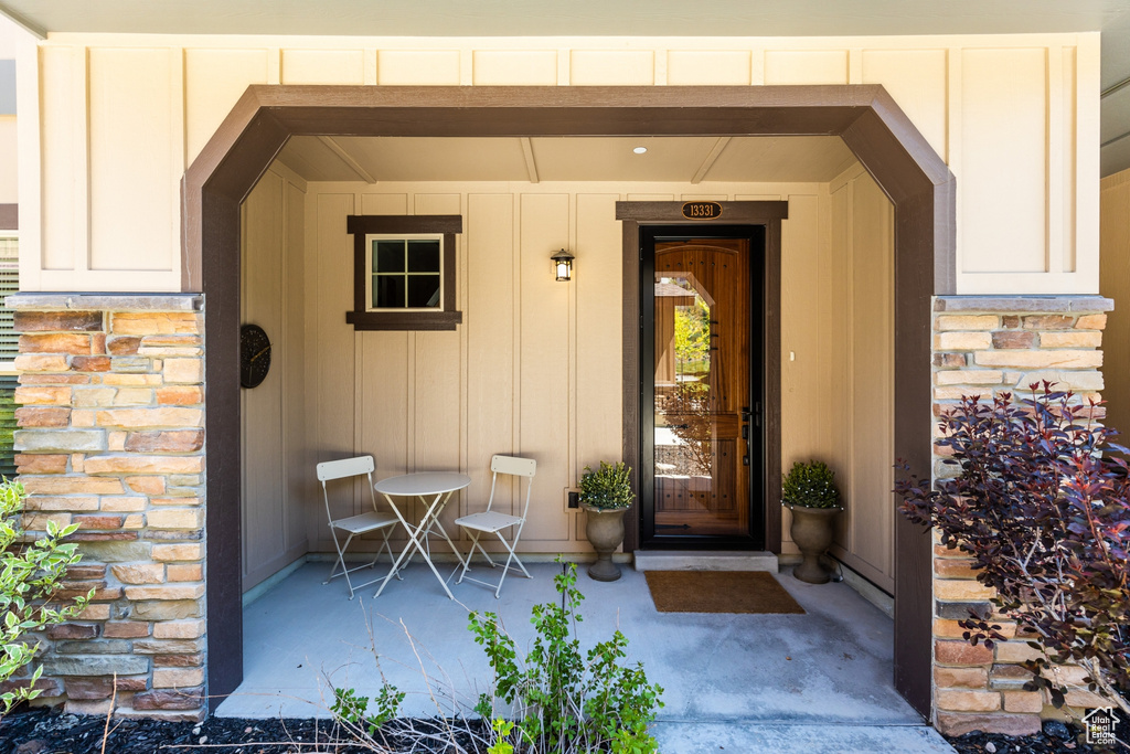 Entrance to property featuring board and batten siding and stone siding