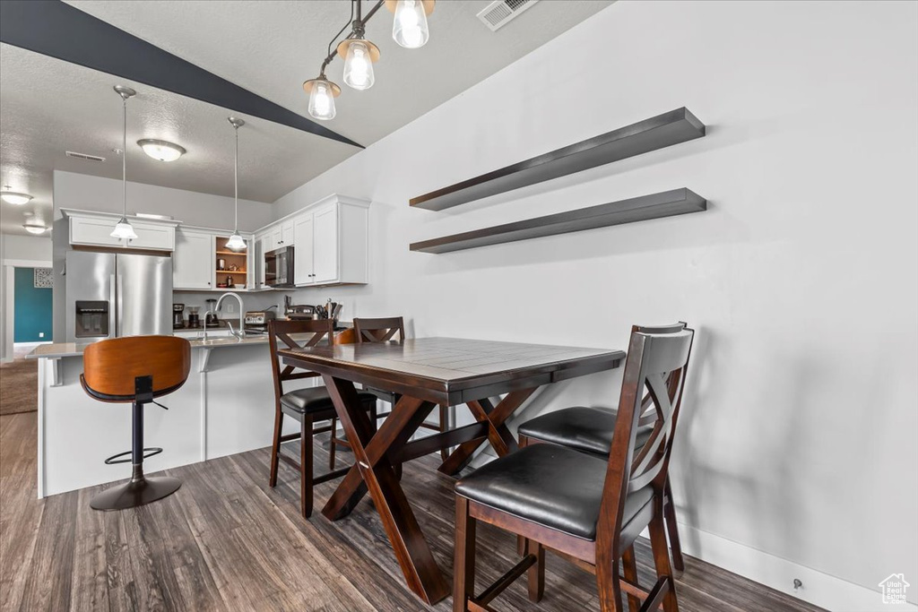 Dining space with visible vents and dark wood-style floors