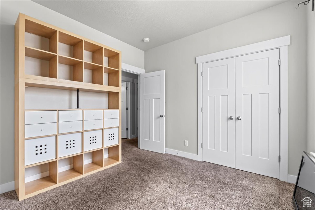 Unfurnished bedroom with carpet floors, a closet, and baseboards