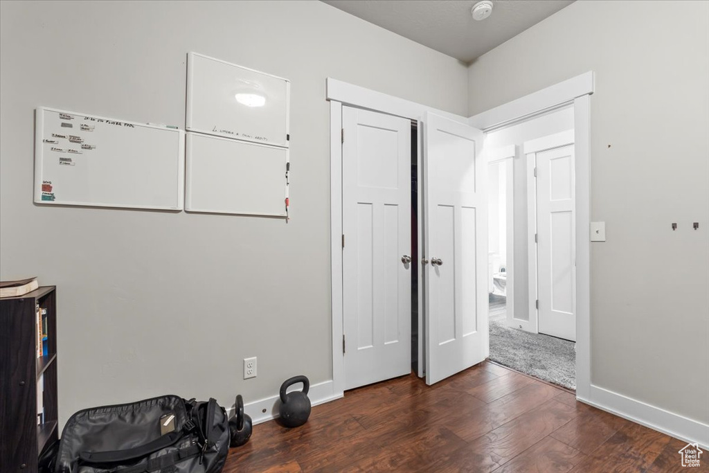 Unfurnished bedroom featuring wood finished floors and baseboards