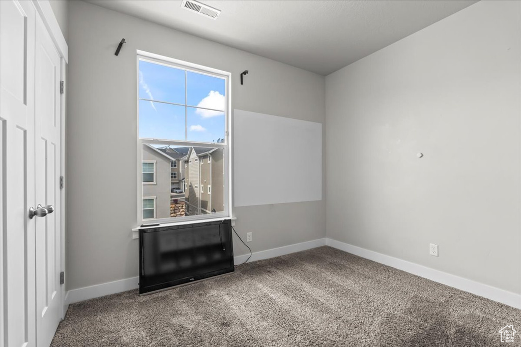 Spare room featuring visible vents, baseboards, and carpet floors
