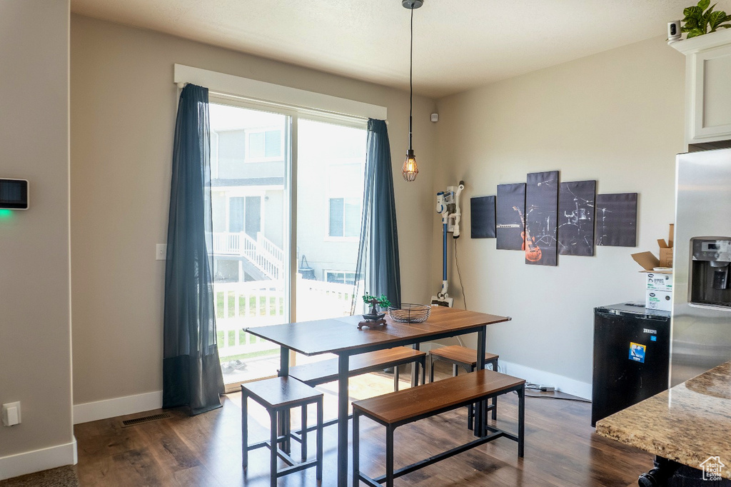 Dining room featuring plenty of natural light and dark wood-style flooring