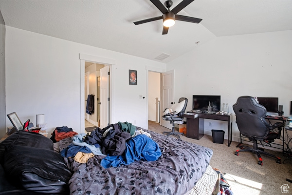 Carpeted bedroom featuring lofted ceiling and a ceiling fan
