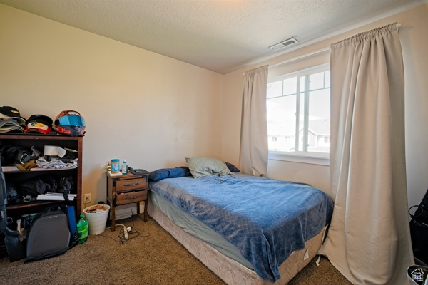 Bedroom featuring carpet and visible vents