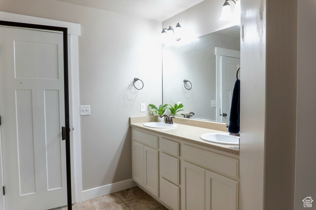 Full bath featuring double vanity and tile patterned floors