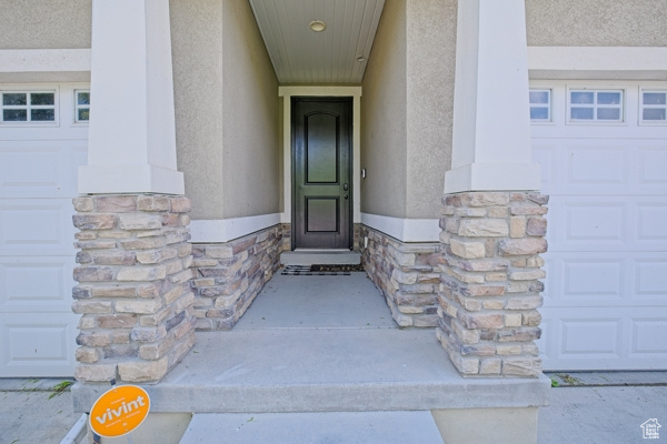 Entrance to property featuring stone siding and stucco siding