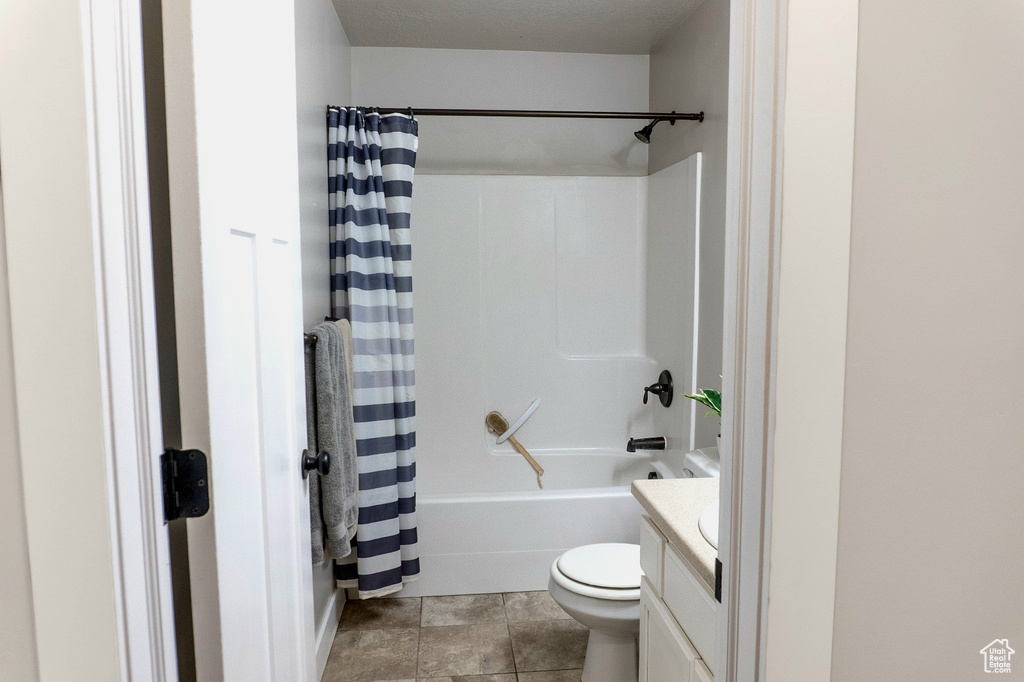Bathroom with vanity, shower / bathtub combination with curtain, and tile patterned flooring