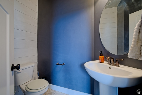 Bathroom featuring tile patterned floors, toilet, and baseboards