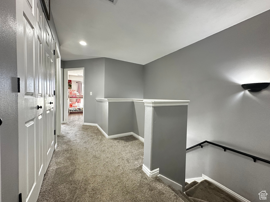 Corridor featuring carpet floors, baseboards, an upstairs landing, and recessed lighting