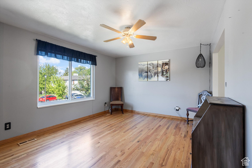 Unfurnished room featuring ceiling fan, baseboards, light wood-type flooring, and visible vents