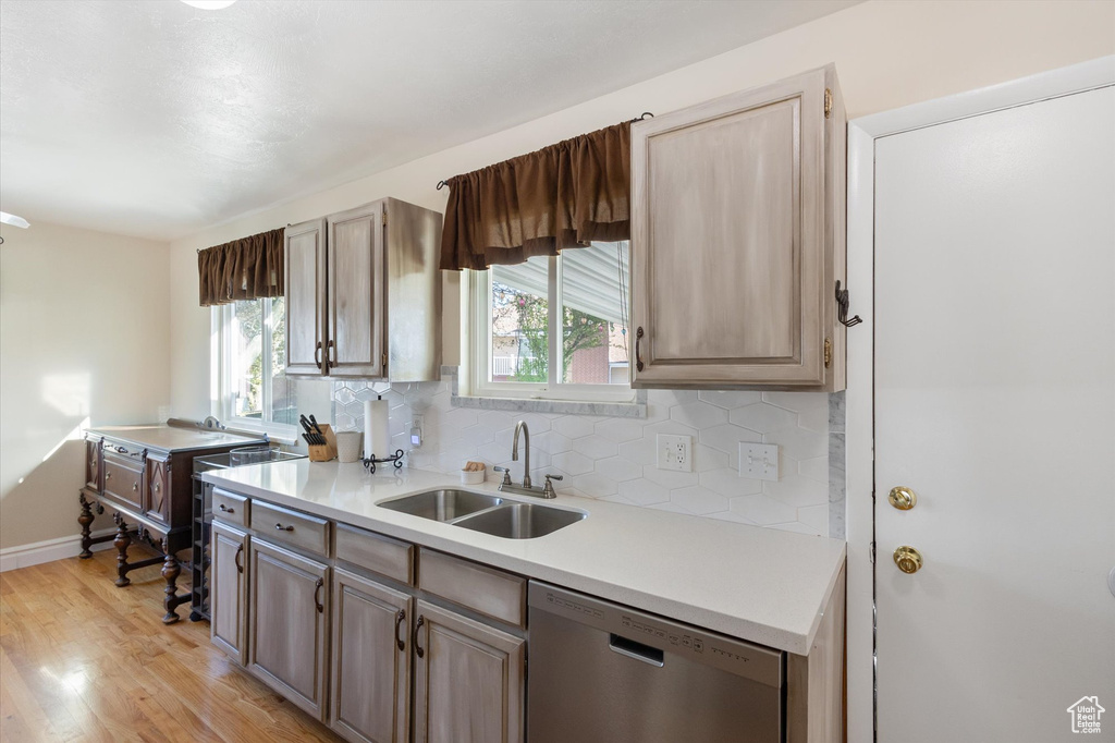 Kitchen with a sink, light wood-type flooring, plenty of natural light, and dishwasher