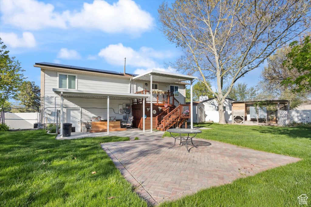 Back of property featuring a patio, fence, a deck, a yard, and stairs