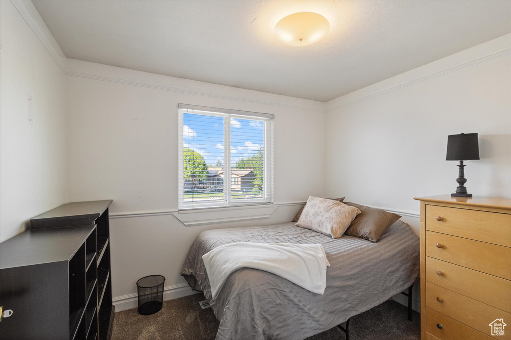 Bedroom featuring baseboards, crown molding, and carpet