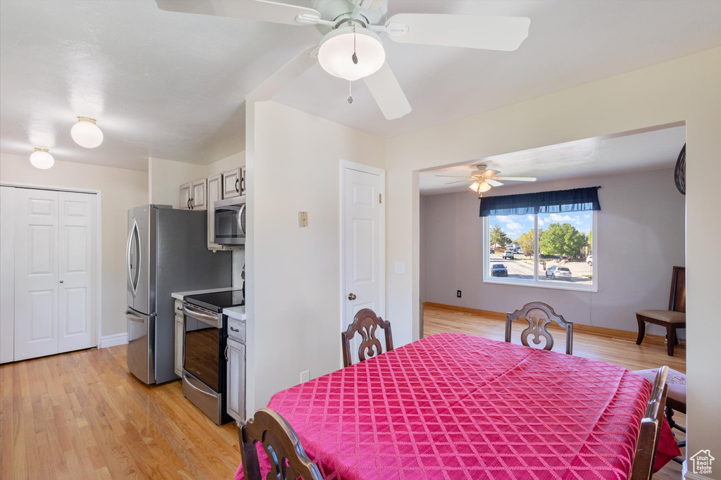 Dining room with light wood-type flooring, baseboards, and a ceiling fan
