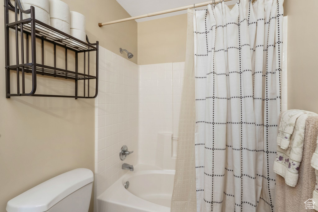 Full bath featuring toilet and shower / bathtub combination with curtain