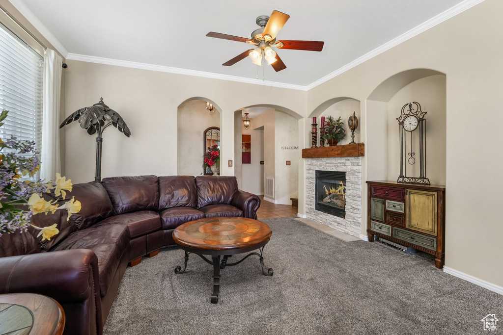 Living room featuring ornamental molding, visible vents, ceiling fan, and arched walkways