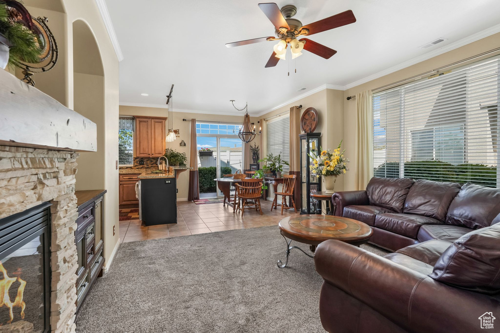 Living area featuring ornamental molding, visible vents, a fireplace, a ceiling fan, and light tile patterned floors
